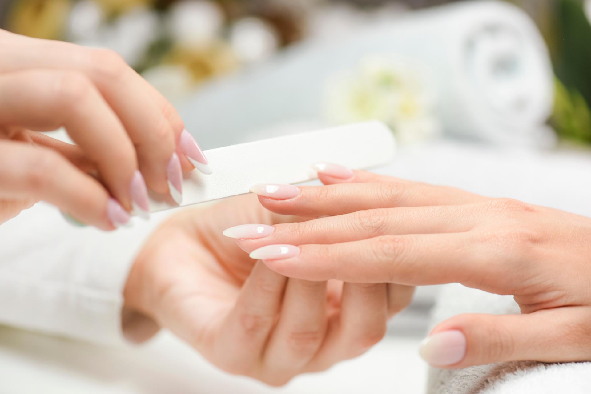 Nagelmanikyr med fil. Vacker nagelvård för kvinna. Efter fyllning.