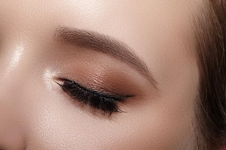 Elegans närbild av kvinnligt öga med klassisk mörkbrun rökig makeup